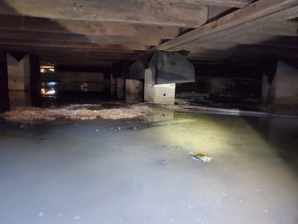 Standing water in a flooded crawl space after a Chicago storm